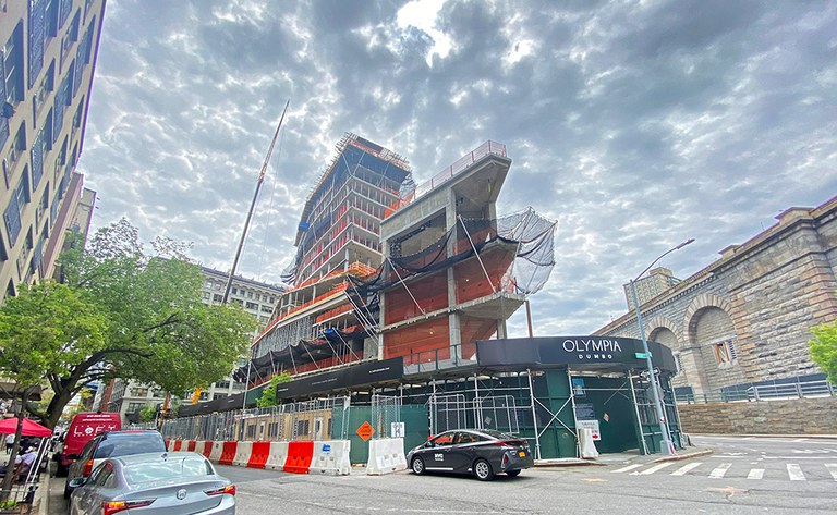 Convex mixed-use building rises next to the Brooklyn Bridge